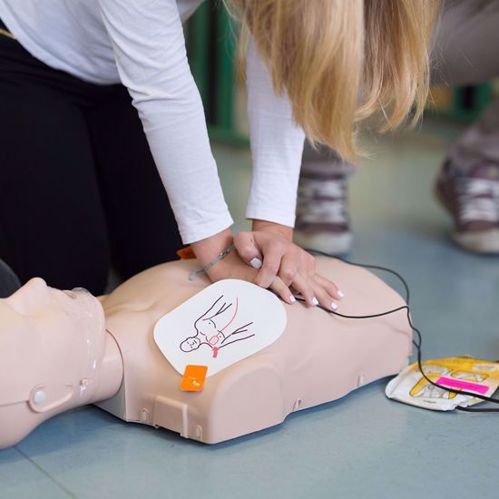 Woman administering CPR on a mannequin